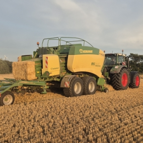 Traktor og halmpresse ved produktion af halmballer i marken