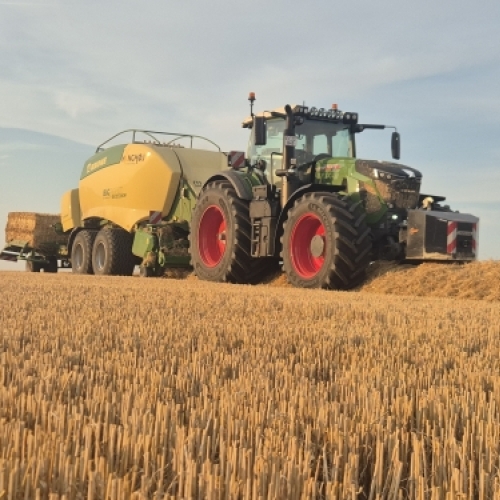 Traktor og presse i markarbejde som en del af moderne planteavl